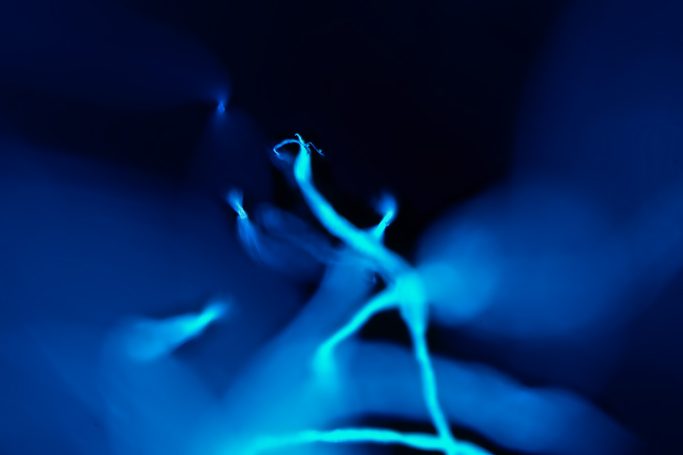 Mikrofoto eines Fussels (Wäschetrockner),  Aufnahme im ultravioletten Licht
